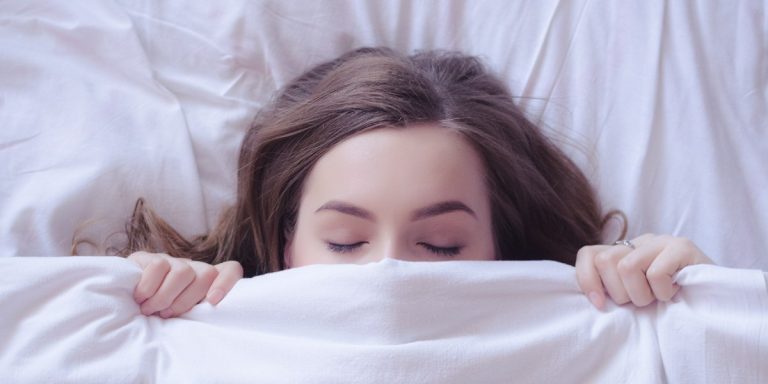 paralizia in somn, femeie care doarme sub plapuma si de confrunta cu paralizia in somn