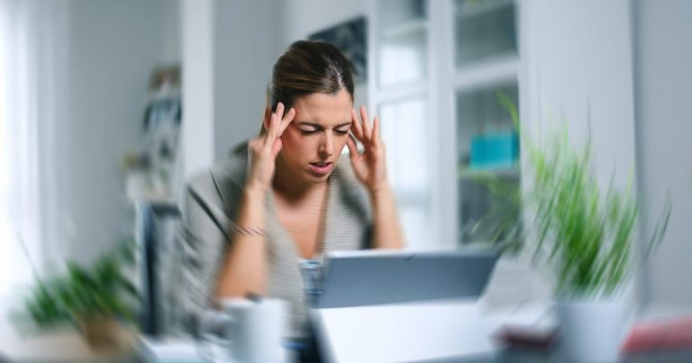 femeie la birou care se confruntă cu amețeli