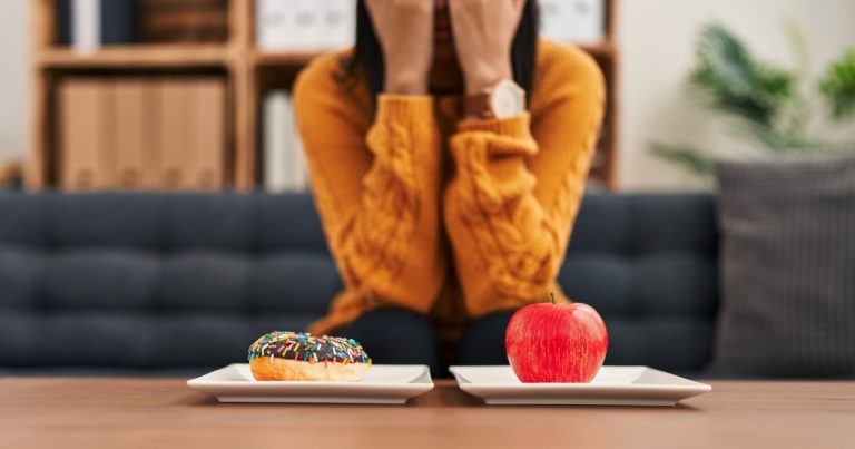 femeie ce alege intre o gogoasa si un mar